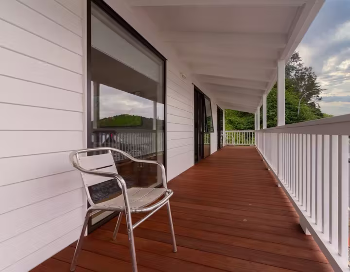An elevated covered deck with a hillside view