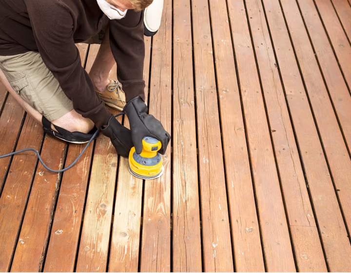Sanding back a weathered timber deck as part of a repair
