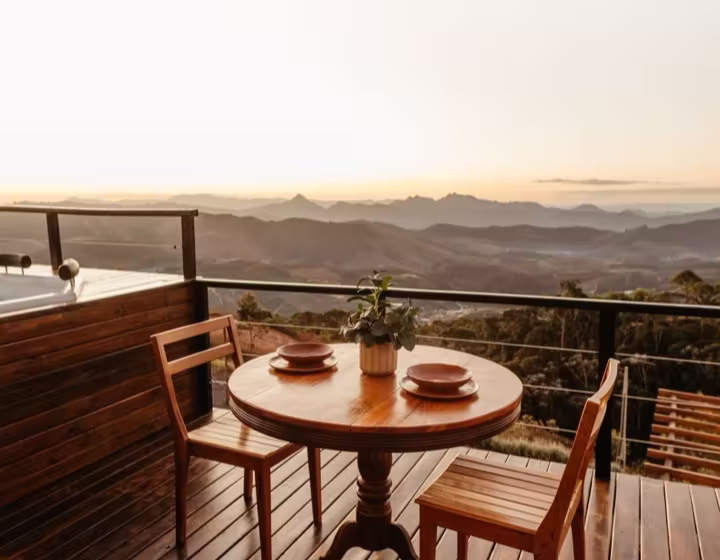 An elevated timber deck on a sloping block with a hillside view